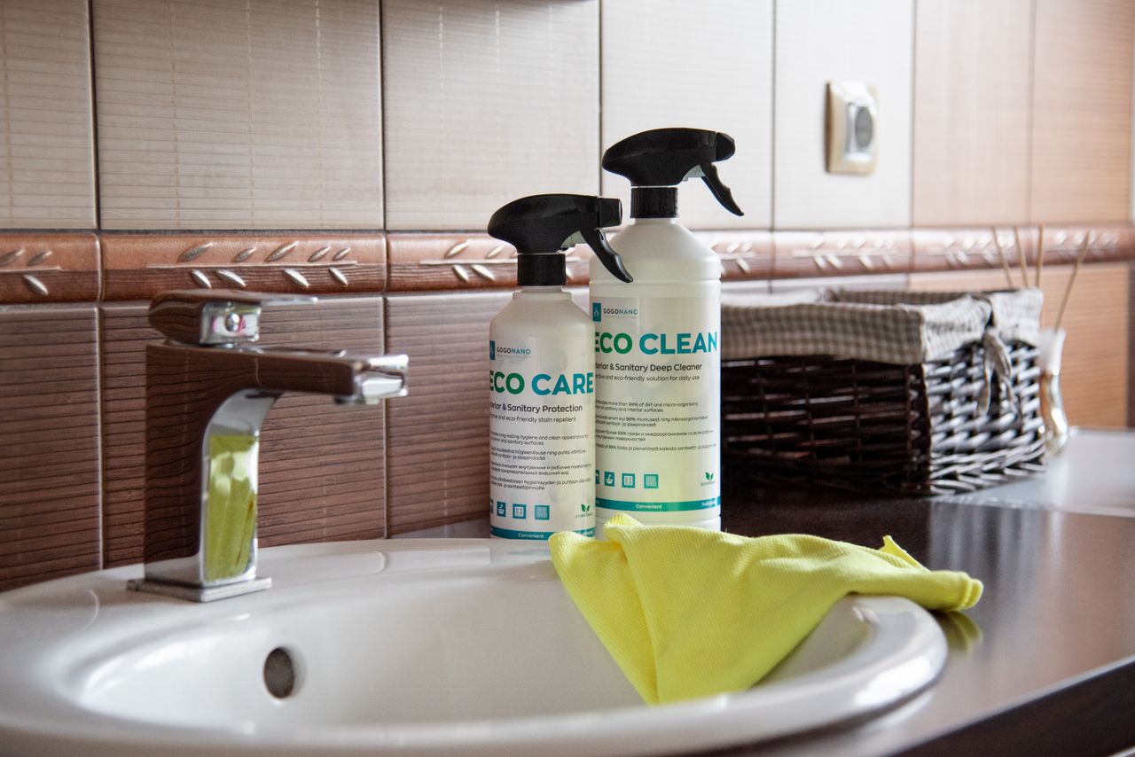 project-01-d Eco-friendly cleaning products displayed on a bathroom sink with tiles and a basket.